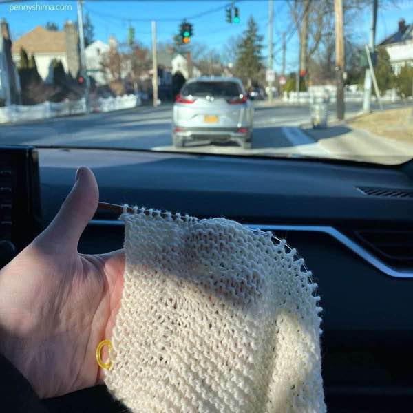 repaired white selvedge being held by a hand in the passenger seat of a car