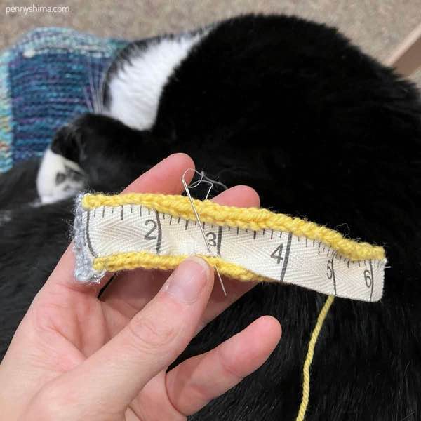 twill tape being sewn to yellow for emotional support tape measure.