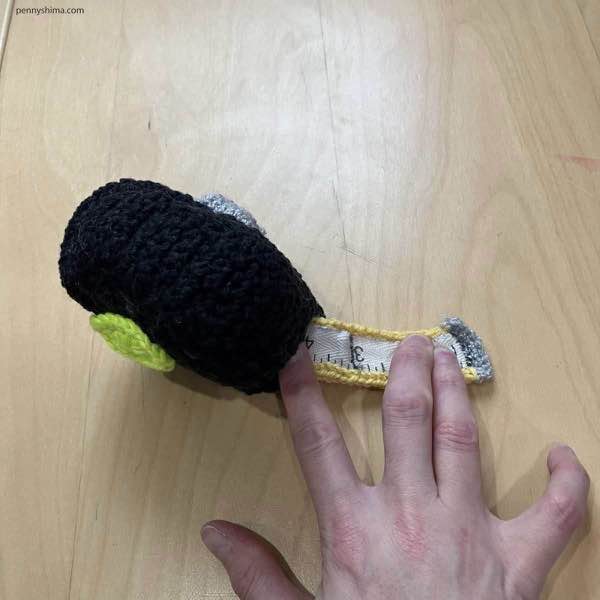 top view of a crochet tape measure with fingers pulling it out further