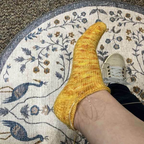right foot showing the heel of a golden yellow sock in progress