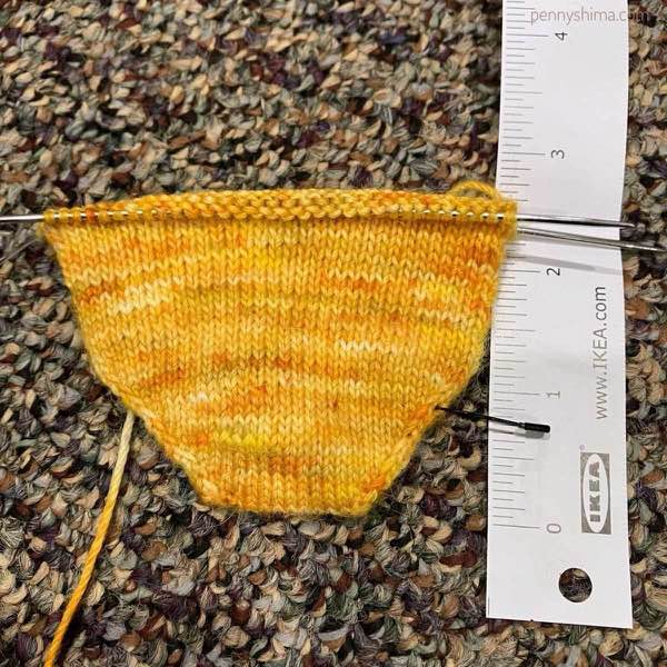 2.5" of sock toe up in progress shown next to a white tape measure (from ikea)