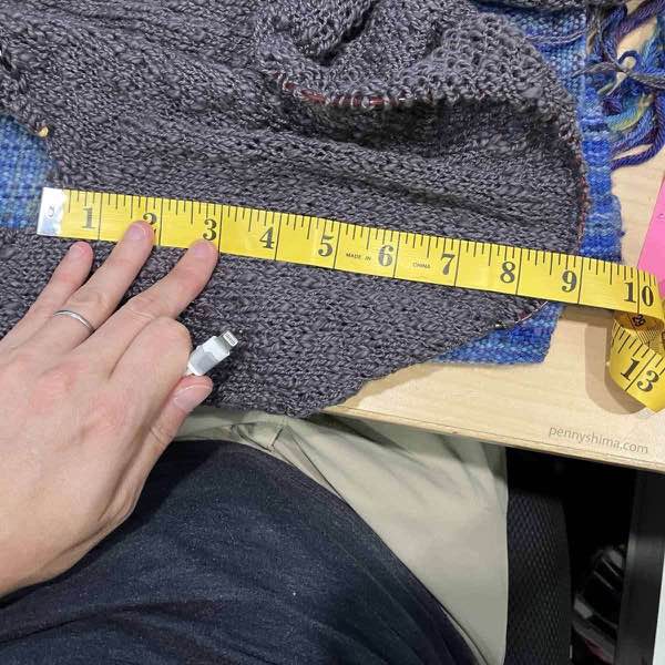 sweater body measures approximate 9 inches with yellow tape measure