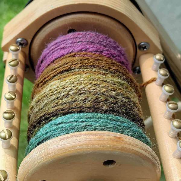 muted autumn rainbow, plyed shown on bobbin