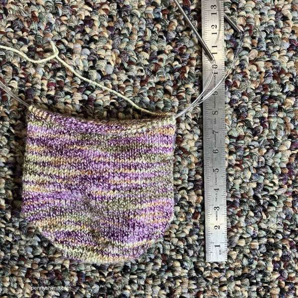 purple/green/yellow sock progress, toe up next to ruler. approximately 7.5cm has been worked.