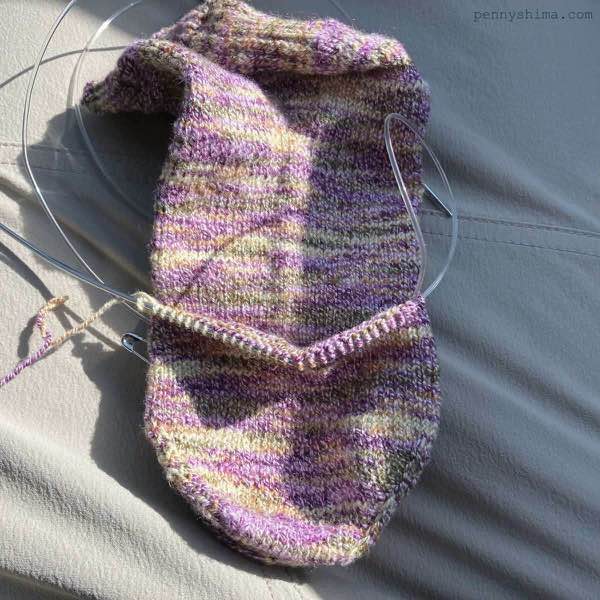 Purple cotton sock with second sock (in progress) on top