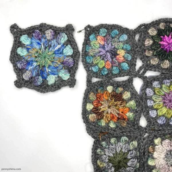 completed crochet motif shown on a white background next to some of a 9-patch of the original sized fingering weight crochet motifs.