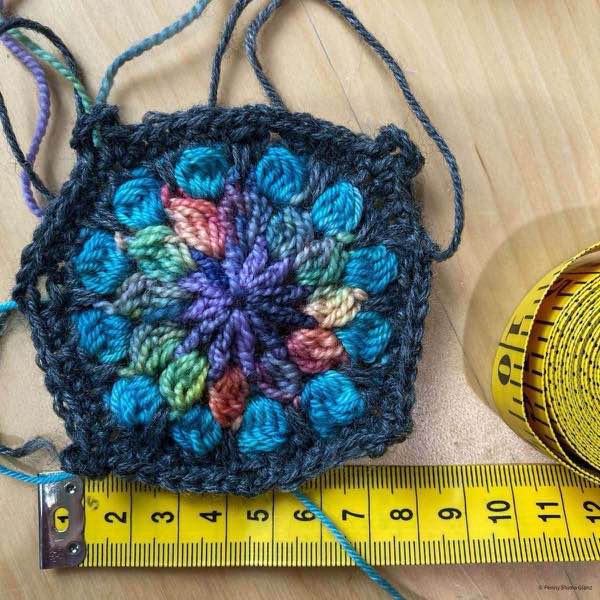 crochet motif next to yellow measuring tape showing approximately 8cm in widith