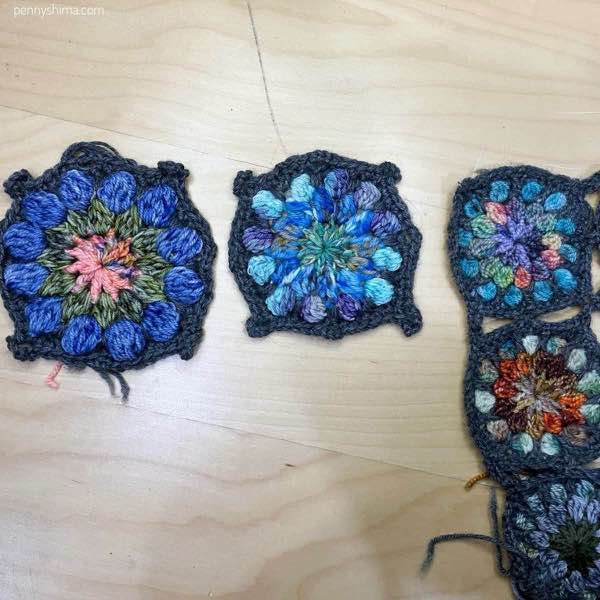 completed crochet motif in dc and hdc shown on a light wooden background next to some of a 9-patch of the original sized fingering weight crochet motifs.