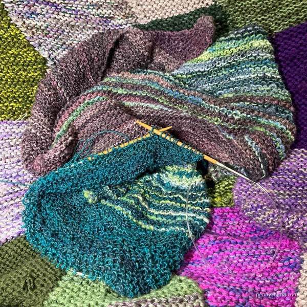 Hand spun and knit shawl with c3 in progress on the garden as safe space blanket