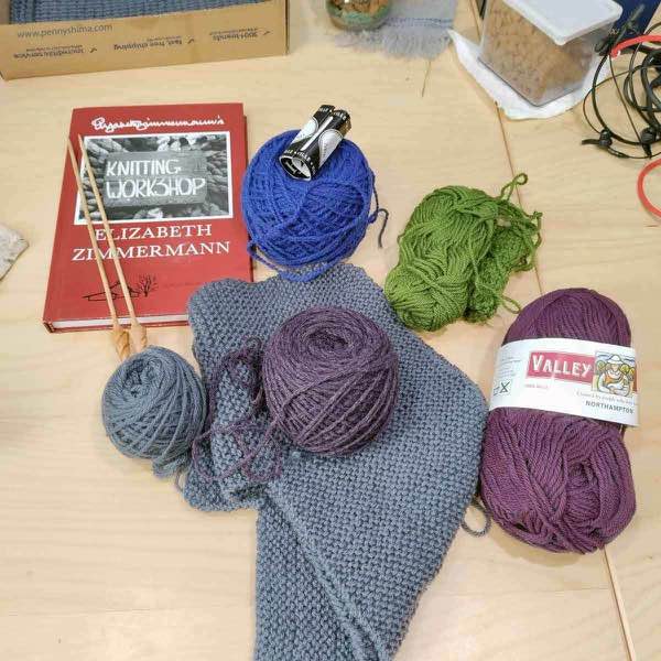 Book "Knitting Workshop", as well as partially knit Rib Warmer Vest, and several partial skeins of yarn