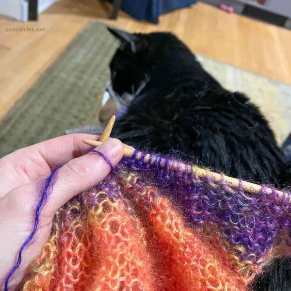 tuxedo cat on a lap with back (purl) side of silk mohair 2ply cardi