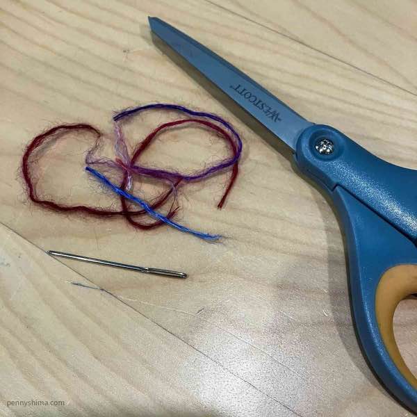silk mohair ends, a tapesty needle, and a pair of scissors