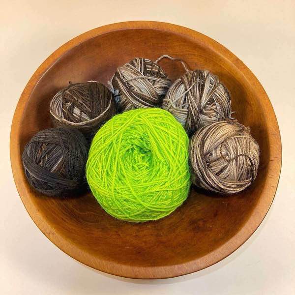 would balls of Artyarns Merino Cloud in a wooden bowl on a white surface. N8A & Fade Kit in 7144