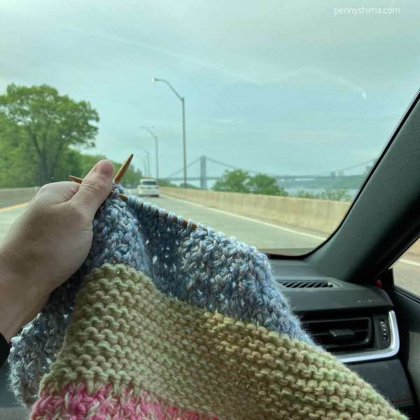 knitting being held up as a passenger. it's a cloudy day.