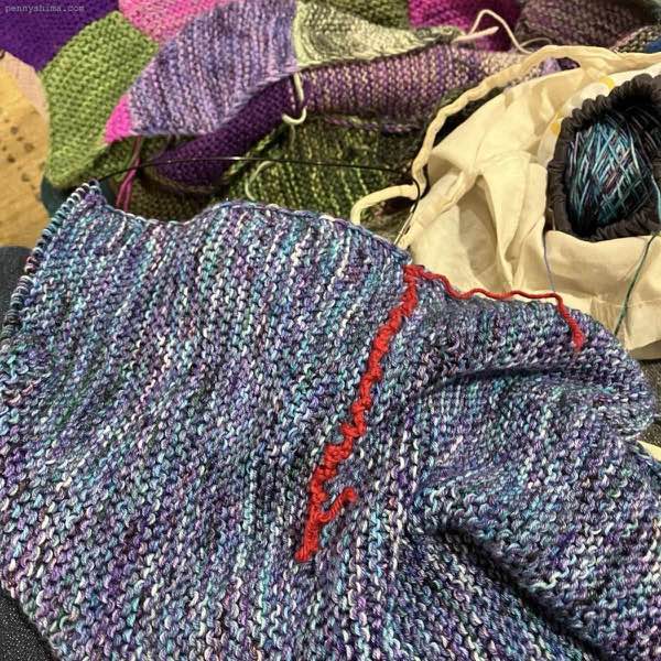 blue purple marled garter stitch fabric. a line of red shows the arm hole.