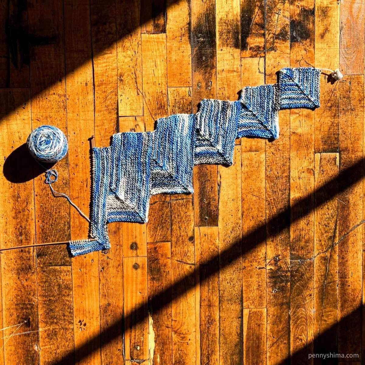 In progress stairmaster scarf shown on an aged wooden floor in the sun