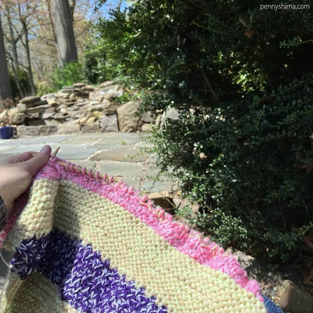 blanket being knit outside on a sunny day